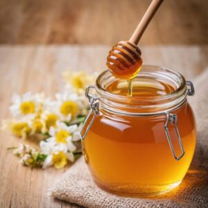Golden honey in a jar with a drizzler