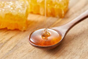 Drizzling golden honey on a spoon